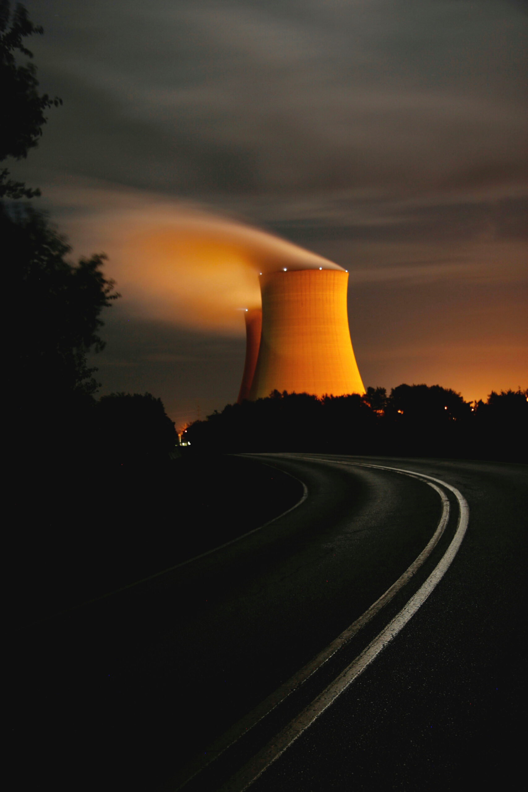 A nuclear power plant on a road at night.