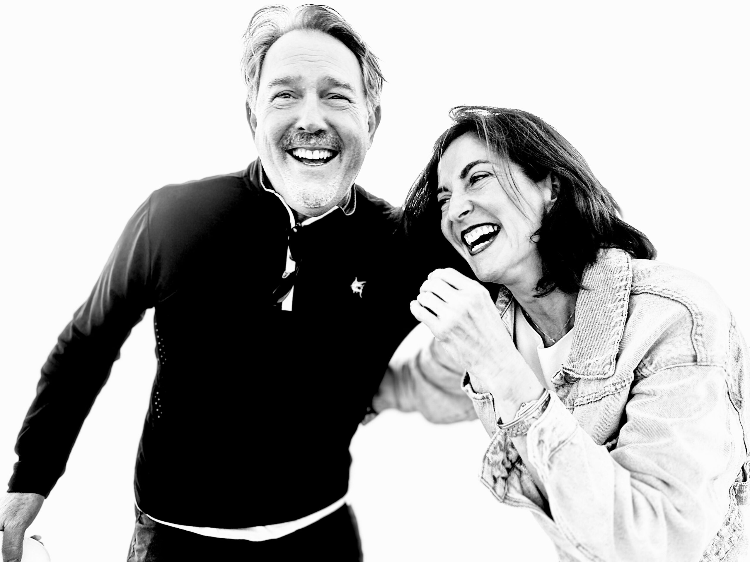 A black and white photo of a man and woman laughing.