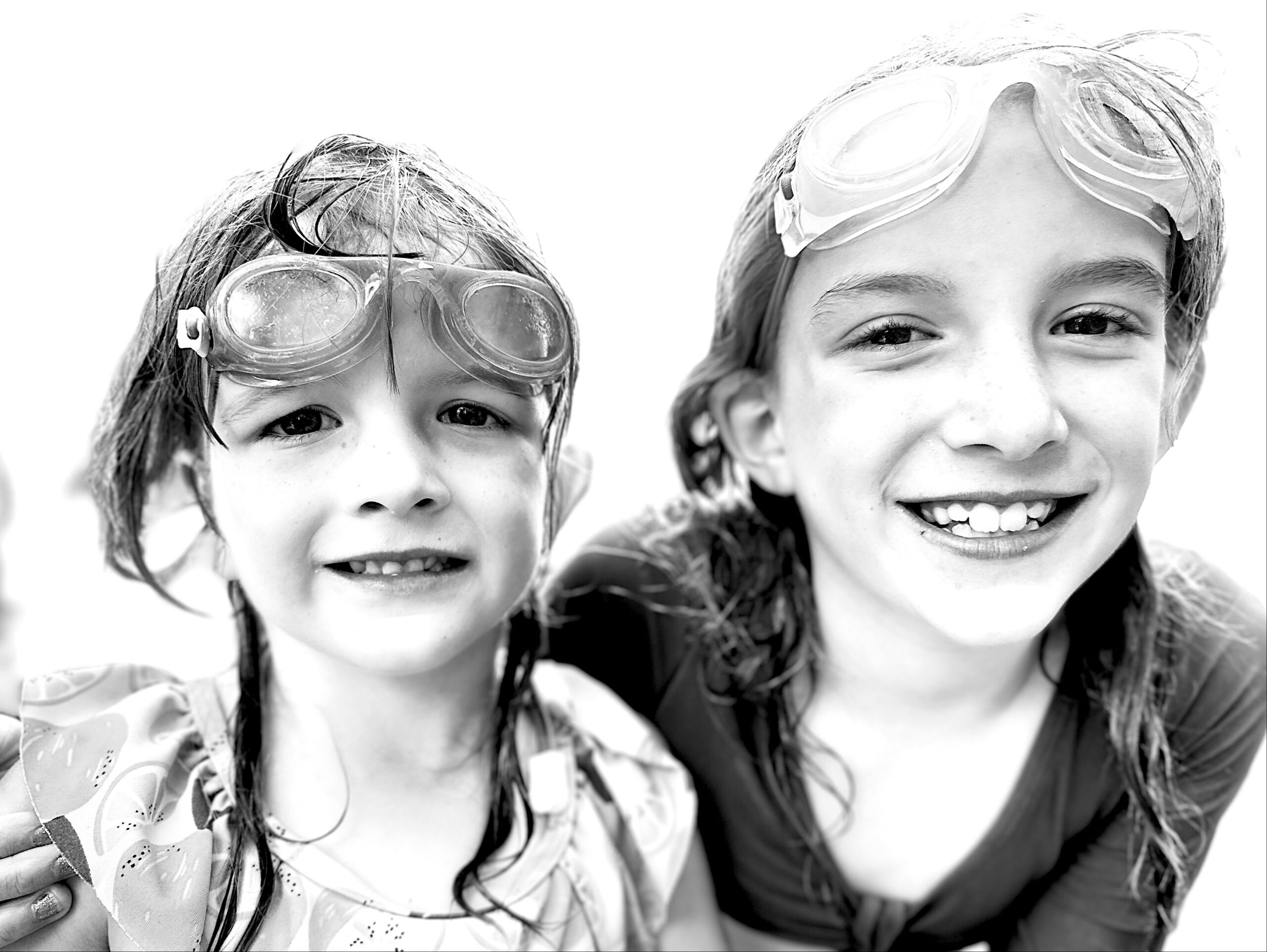 Black and white photo of two girls wearing goggles.