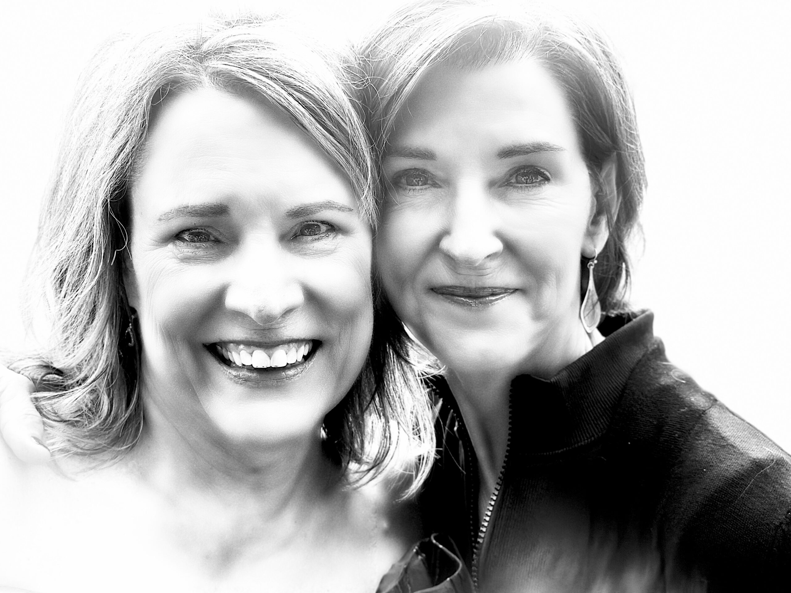 A black and white photo of two women posing for a photo.