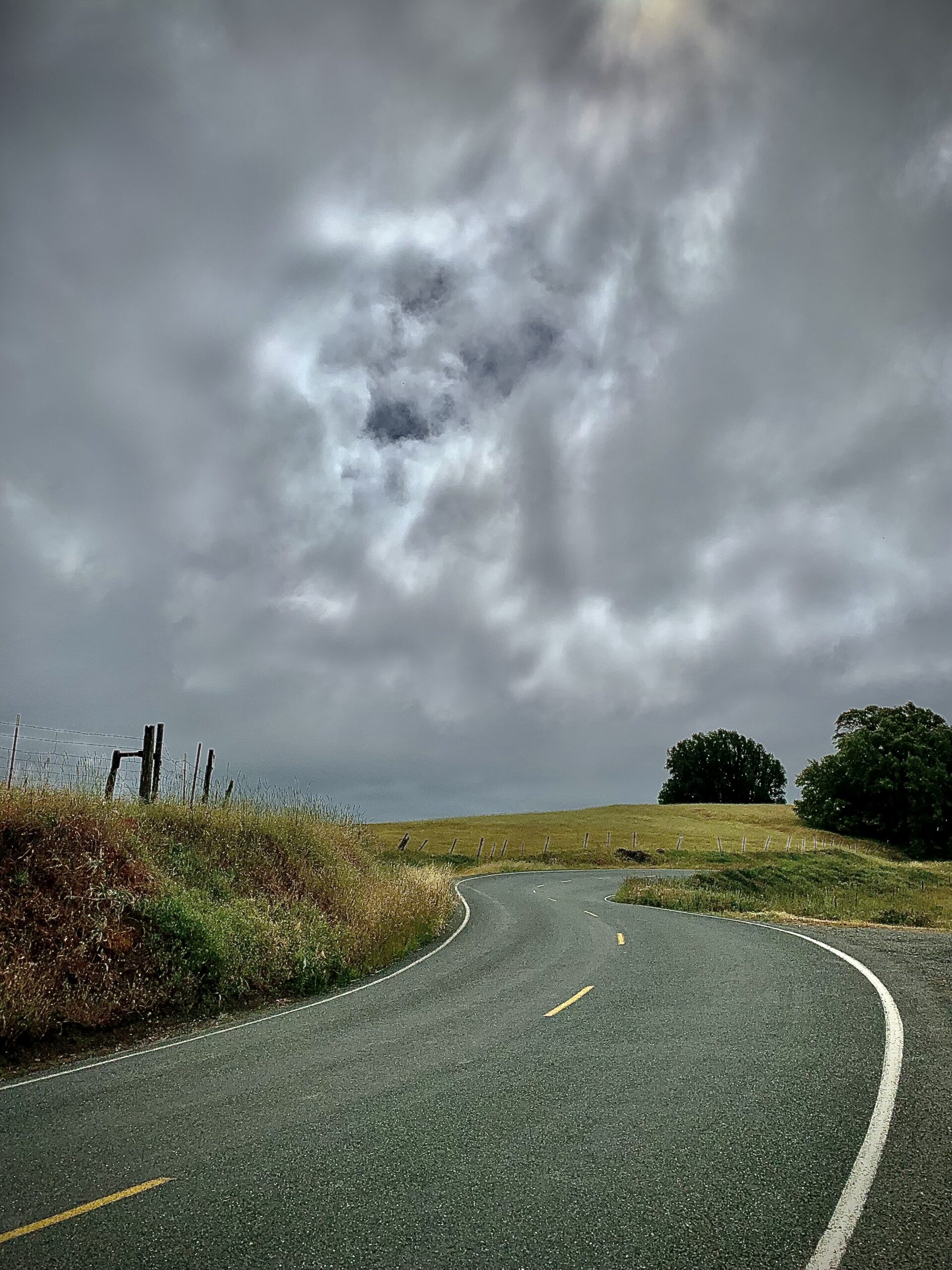 An empty road under a cloudy sky.
